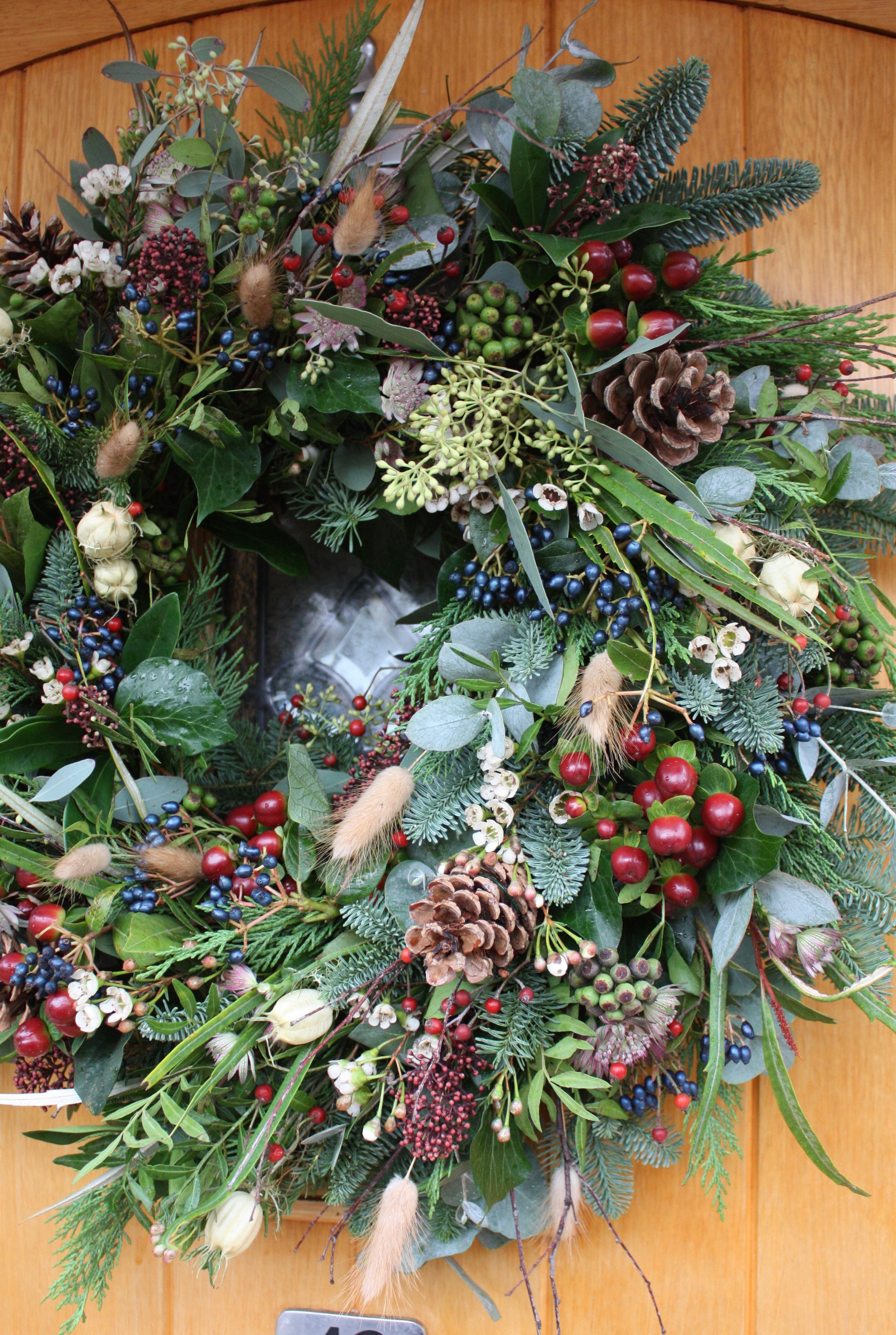 Festive door wreath with red berries and pinecones